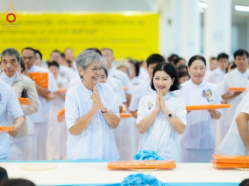 กลุ่มพุทธศาสนิกชนสวมชุดสีขาวกำลังพนมมือด้วยความสงบในพิธีทางศาสนา