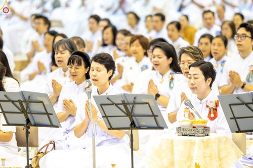 กลุ่มพุทธศาสนิกชนสวมชุดขาวนั่งพนมมือสวดมนต์ในพิธีทางศาสนา