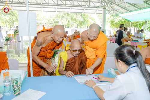 พระภิกษุสงฆ์กำลังลงทะเบียนเข้าร่วมงานสัมมนาโดยมีเจ้าหน้าที่คอยอำนวยความสะดวก