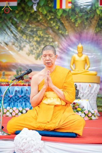 พระภิกษุสงฆ์นั่งพนมมือทำสมาธิบนอาสนะหน้าพระพุทธรูป