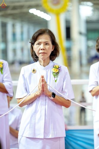 หญิงสาวสวมชุดขาวพนมมือประกอบพิธีกรรมทางศาสนา