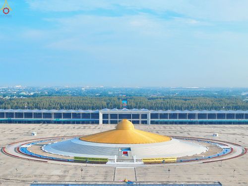 มหาธรรมกายเจดีย์สีทองรูปทรงโดมตั้งอยู่หน้าอาคารสภาธรรมกายสากลในพื้นที่โล่งกว้าง
