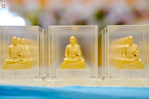 พระพุทธรูปสีทองขนาดเล็กในกล่องใสวางเรียงกันหลายองค์