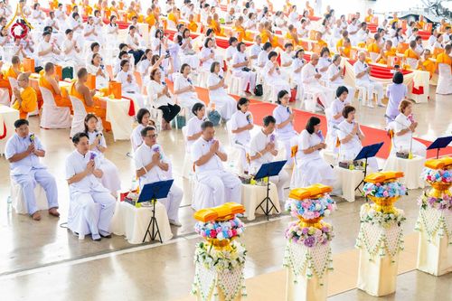 พุทธศาสนิกชนชุดขาวนั่งพนมมือร่วมพิธีทางศาสนาภายในสภาธรรมกายสากล