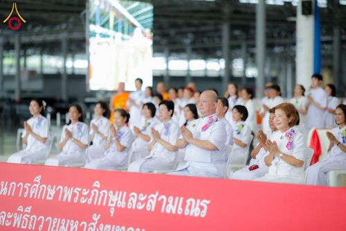 กลุ่มพุทธศาสนิกชนชุดขาวนั่งพนมมือร่วมพิธีทางศาสนาภายในอาคารสภาธรรมกายสากล