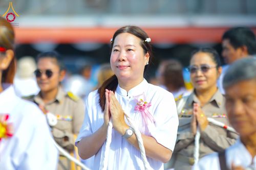 หญิงไทยสวมชุดขาวประนมมือไหว้ในพิธีทางศาสนา ท่ามกลางผู้เข้าร่วมพิธีคนอื่นๆ