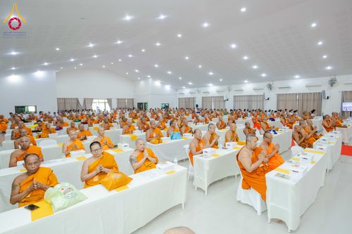 พระภิกษุสงฆ์จำนวนมากนั่งฟังการสัมมนาภายในห้องประชุมขนาดใหญ่ที่มีการจัดโต๊ะเก้าอี้อย่างเป็นระเบียบ