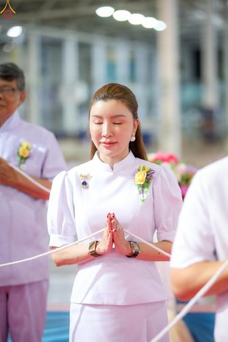 หญิงสาวสวมชุดสีขาวพนมมือด้วยความสงบในพิธีทางศาสนา ณ วัดพระธรรมกาย