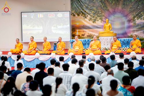 พระภิกษุสงฆ์นั่งสมาธิบนเวทีท่ามกลางพุทธศาสนิกชนที่มาร่วมงานบุญ