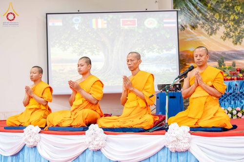 พระภิกษุสงฆ์ 4 รูปนั่งพนมมือบนเวทีเพื่อประกอบพิธีกรรมทางศาสนา
