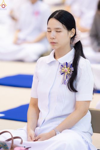 หญิงสาวสวมชุดสีขาวนั่งหลับตาทำสมาธิอย่างสงบ