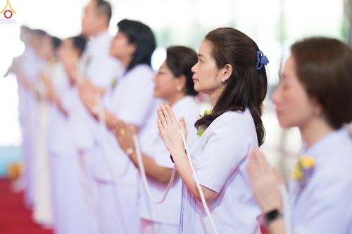 กลุ่มคนสวมชุดขาวพนมมือประกอบพิธีกรรมทางศาสนาอย่างสงบ