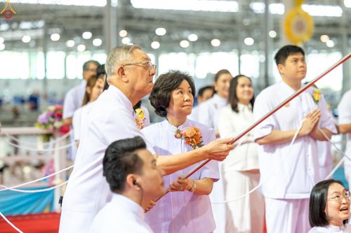 กลุ่มสาธุชนสวมชุดสีขาวกำลังร่วมพิธีจุดเทียนใจ ไฟนิรันดร์ อนันตชัย