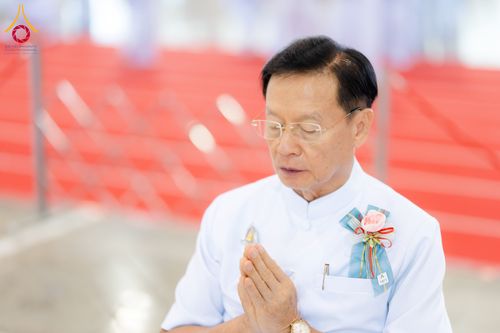 ชายสวมชุดขาวพนมมือด้วยความสงบในพิธีทางศาสนา