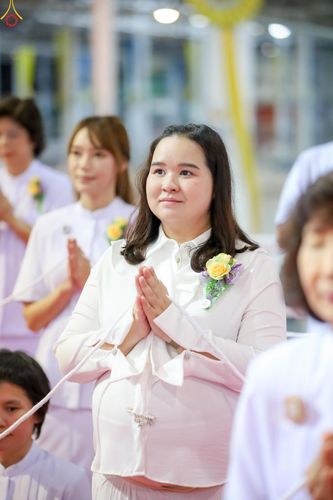 หญิงสาวสวมชุดสีขาวพนมมือด้วยความสงบในพิธีทางศาสนา
