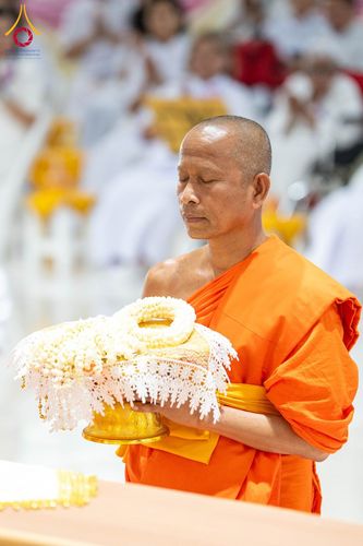 พระภิกษุสงฆ์ถือพานพวงมาลัยดอกมะลิสีขาวด้วยท่าทางสำรวม