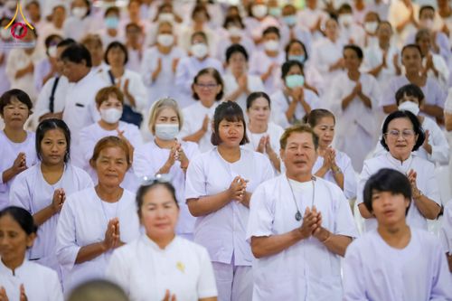 กลุ่มคนสวมชุดสีขาวพนมมือร่วมกิจกรรมทางศาสนา