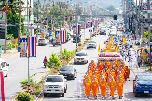 ขบวนพระภิกษุสงฆ์เดินเท้าอัญเชิญพระพุทธรูปบนรถบุษบกท่ามกลางการจราจรบนถนน