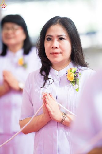 หญิงสาวสวมชุดสีขาวพนมมือด้วยความสงบในพิธีทางศาสนา