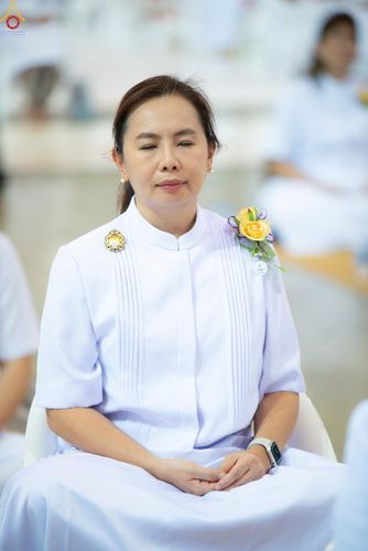 หญิงสาวสวมชุดสีขาวนั่งหลับตาทำสมาธิอย่างสงบ