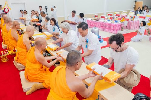 พระภิกษุสงฆ์และพุทธศาสนิกชนกำลังประกอบพิธีถวายผ้าป่าภายในอาคาร