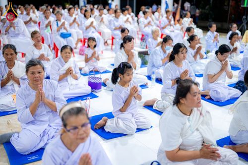กลุ่มคนสวมชุดสีขาวนั่งพนมมือปฏิบัติธรรมในโครงการอบรมอุบาสิกาแก้ว