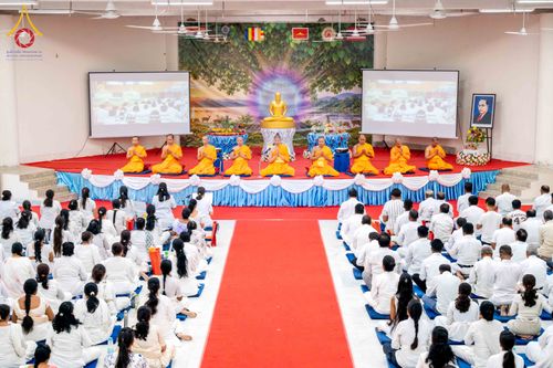 พระภิกษุสงฆ์และพุทธศาสนิกชนร่วมพิธีทางศาสนาภายในหอประชุมขนาดใหญ่