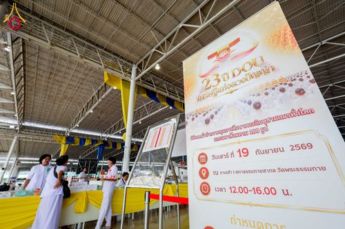 ป้ายไวนิลแสดงรายละเอียดงานครบรอบ 23 ปี DOU และพิธีถวายมหาสังฆทาน ตั้งอยู่ภายในอาคารสภาธรรมกายสากล