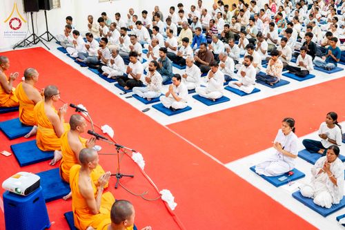 พระภิกษุและพุทธศาสนิกชนจำนวนมากนั่งสมาธิปฏิบัติธรรมร่วมกันในอาคาร