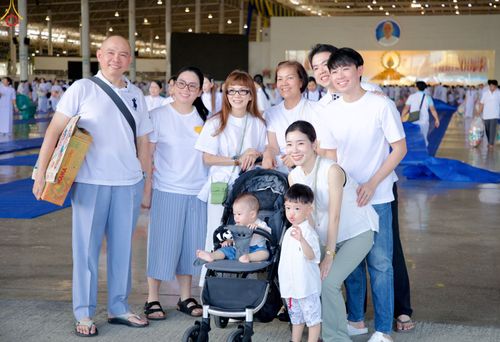 กลุ่มครอบครัวสวมเสื้อสีขาวถ่ายภาพร่วมกันในอาคารสภาธรรมกายสากล