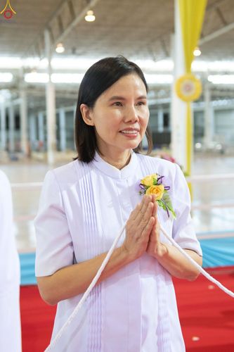 หญิงสาวสวมชุดขาวพนมมือประกอบพิธีกรรมทางศาสนาภายในอาคาร