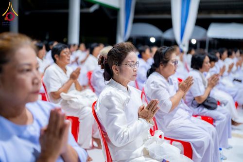 กลุ่มผู้หญิงสวมชุดขาวนั่งพนมมือปฏิบัติธรรมในโครงการอบรมอุบาสิกาแก้ว