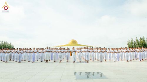 กลุ่มนักเรียนนายสิบตำรวจสวมชุดขาวพนมมือปฏิบัติธรรมกลางแจ้ง
