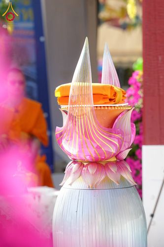 พานพุ่มสีชมพูวางผ้าไตรจีวรสีเหลืองทองในพิธีทางศาสนา