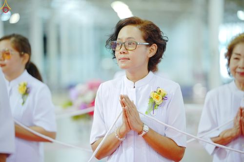 หญิงสวมชุดสีขาวพนมมือด้วยความสงบในพิธีทางศาสนา