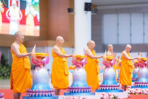 พระภิกษุสงฆ์กำลังประกอบพิธีทอดผ้าป่าบนพานพุ่มดอกบัวในพิธีทางศาสนา