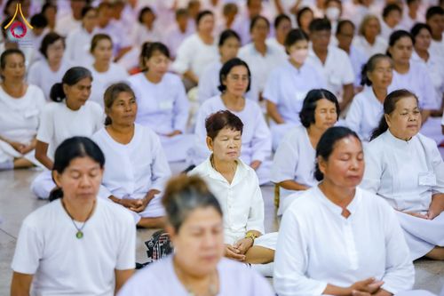 กลุ่มอุบาสิกาหลายท่านสวมชุดสีขาวนั่งหลับตาทำสมาธิในพื้นที่ปฏิบัติธรรม