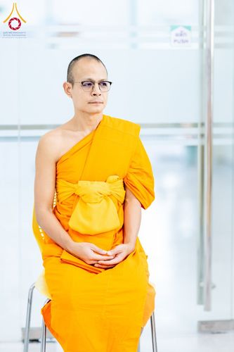 พระภิกษุสงฆ์สวมแว่นตานั่งสำรวมบนเก้าอี้
