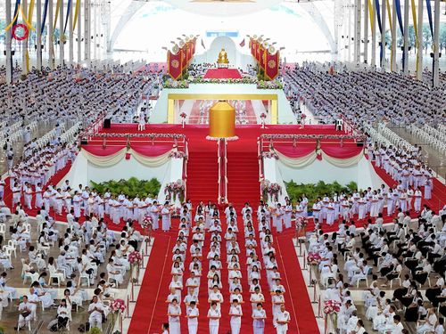 พุทธศาสนิกชนสวมชุดขาวจำนวนมากร่วมพิธีทอดผ้าป่าภายในอาคารสภาธรรมกายสากล