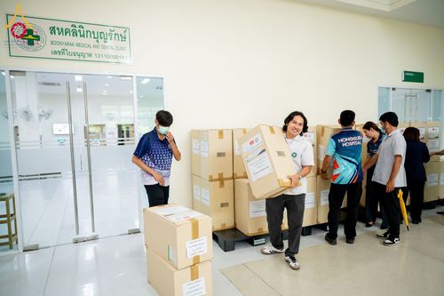 กลุ่มเจ้าหน้าที่กำลังช่วยกันขนย้ายกล่องกระดาษบรรจุยาภายในอาคารศูนย์การแพทย์บุญรักษา