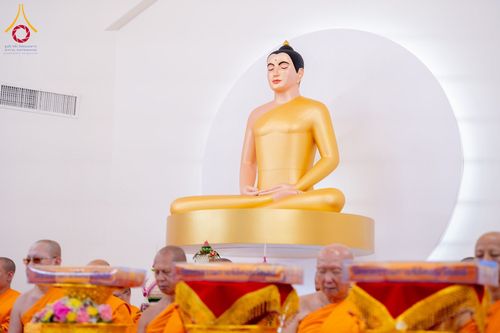 พระพุทธรูปสีทองประดิษฐานอยู่ด้านหน้าพระภิกษุสงฆ์ในพิธีทางศาสนา