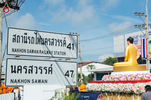 ป้ายสถานีรถไฟนครสวรรค์และพระพุทธรูปสีทองบนรถประดับดอกไม้