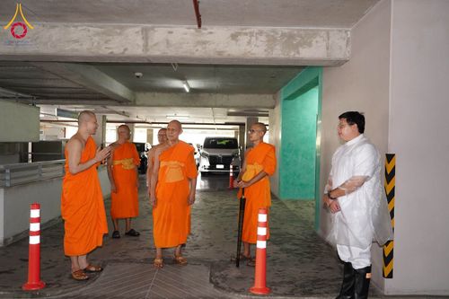 กลุ่มพระสงฆ์และเจ้าหน้าที่กำลังเดินตรวจความเรียบร้อยภายในอาคารจอดรถ