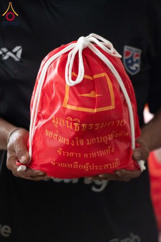 ถุงผ้าสีแดงสำหรับใส่เครื่องอุปโภคบริโภคที่มีข้อความมูลนิธิธรรมกาย