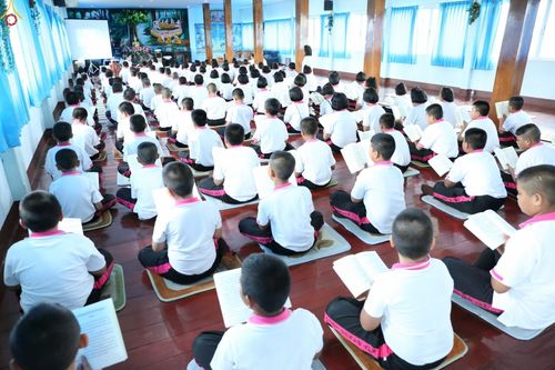 นักเรียนและคณะครูโรงเรียนวัดบางพลีใหญ่กลางนั่งสวดมนต์บทธัมมจักกัปปวัตตนสูตรพร้อมกันภายในอาคารเรียน