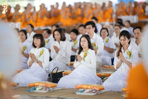 พุทธศาสนิกชนชายหญิงนั่งพนมมือประกอบพิธีบุพเปตพลีภายในหอฉันคุณยายอาจารย์มหารัตนอุบาสิกาจันทร์ ขนนกยูง