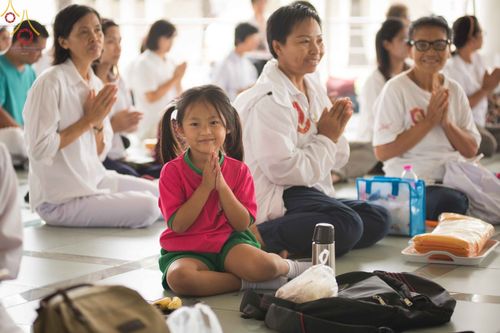 เด็กหญิงพนมมือร่วมพิธีทำบุญอุทิศส่วนกุศลท่ามกลางสาธุชนที่วัดพระธรรมกาย