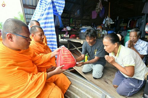 พระสงฆ์กำลังส่งมอบถุงยังชีพให้แก่ชาวบ้านที่ประสบภัยน้ำท่วม
