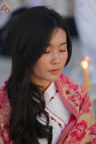 หญิงสาวหลับตาทำสมาธิในพิธีจุดประทีปถวายเป็นพุทธบูชาและบูชาธรรมมหาปูชนียาจารย์