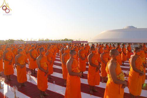 คณะสงฆ์จำนวนมากยืนเข้าแถวร่วมพิธีจุดประทีปถวายเป็นพุทธบูชา ณ อนุสรณ์สถานบางปลา